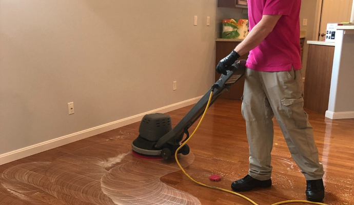 worker cleaning wooden floor